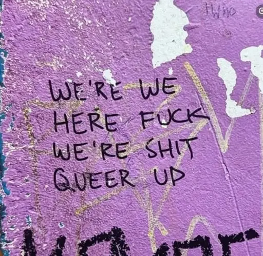 Graffiti that, read from left to right top to bottom, says, “we’re we here fuck we’re shit queer up”