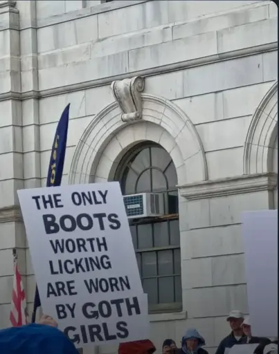 protest sign that says "the only boots worth licking are worn by GOTH GORLS"